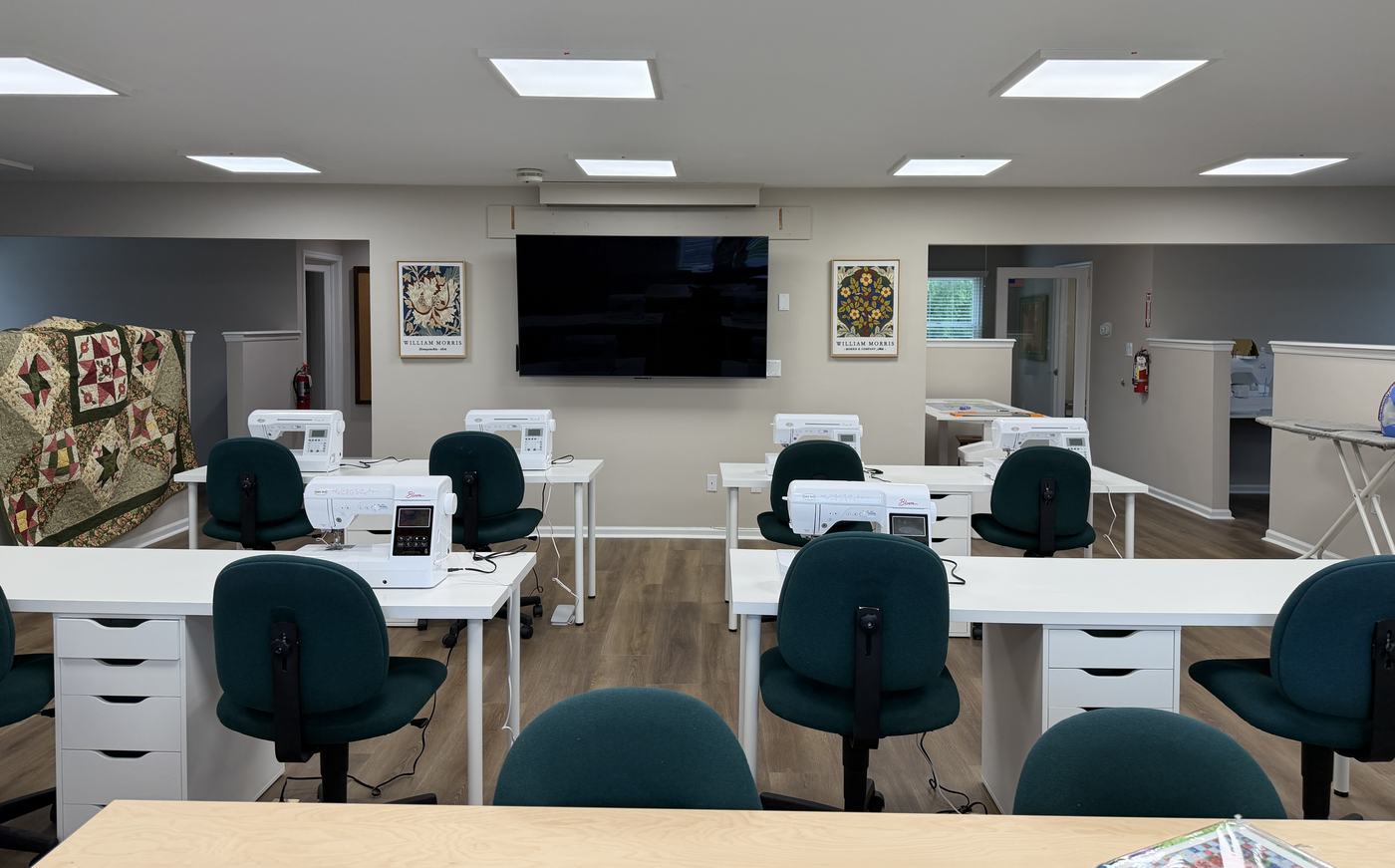 Workstations with teal chairs and Baby Lock machines ready for class